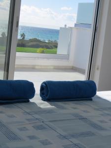a room with two blue pillows in front of a window at Royal Sugar in Ayia Napa +47 photos