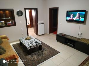 a living room with a couch and a flat screen tv at Rodi Home in Sotíra