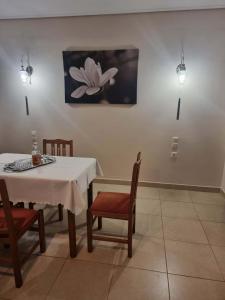 a dining room with a table and chairs and a painting at Rodi Home in Sotíra