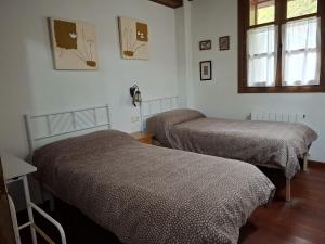 a room with two beds and a window at Apartamento rùstico Escunhau in Escuñau