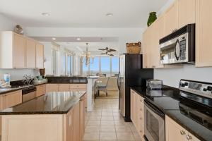 a kitchen with wooden cabinets and black counter tops at La Playa 801 in Perdido Key