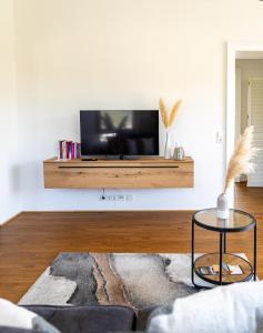 a living room with a flat screen tv on a wall at Ferienwohnungen Moselpanorama und Moselblick in Bullay