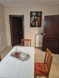 a table with a white table cloth and a bottle on it at Rodi Home in Sotíra +12 photos