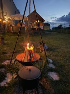 a fire pit in a yard with a grill at Islandzka chatka- Jacuzzi i sauna w cenie in Mżyki