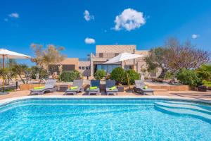 a swimming pool with chairs and umbrellas at Son Vigili in Campos