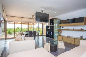 a living room with white furniture and a dining room at Son Vigili in Campos