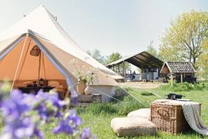 a tent in a field with flowers in the grass at Smuk Bell Tent Glamping nabij het water in Friesland in Echtenerbrug