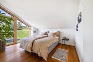 a bedroom with a large bed and a large window at Chalet Bergblick in Rimsting