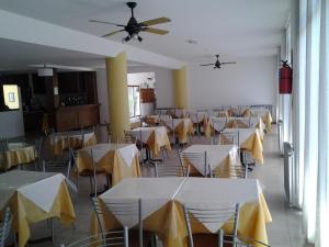 comedor con mesas y sillas y techo en Hotel Correa Playa en San Clemente del Tuyú