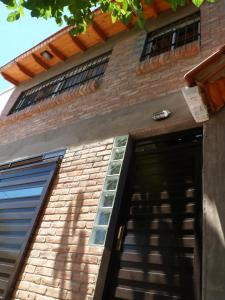 un edificio de ladrillo con puerta y ventanas en Monoambiente Luminoso y Tranquilo en Mendoza