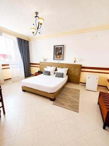 a large bedroom with a bed and a table at Hôtel Shalimar in Antananarivo +5 photos