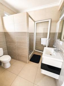 a bathroom with a white sink and a toilet at Hôtel Shalimar in Antananarivo