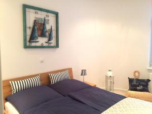 ein Schlafzimmer mit einem Bett und einem Bild an der Wand in der Unterkunft Apartment Warnemünde 10 in Warnemünde