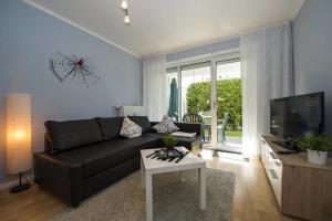 a living room with a black couch and a tv at Ferienwohnung Strandgut im Ostseebad Baabe in Baabe