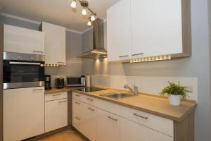 a kitchen with white cabinets and a sink at Ferienwohnung Strandgut im Ostseebad Baabe in Baabe