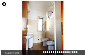 ポルト・オッティオルにあるPorto Ottioluのバスルーム(洗面台、トイレ付)、窓が備わります。