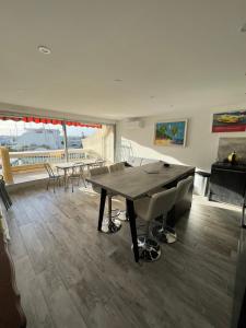 a dining room with a wooden table and chairs at La Marina de Lairan 2 chambres terrasse vue Port de Plaisance in Le Grau-du-Roi