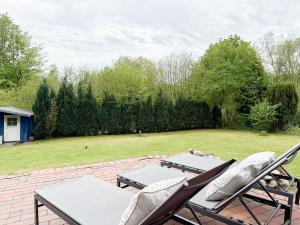 a patio with two chairs and two tables and a field at Seebär in Scharbeutz