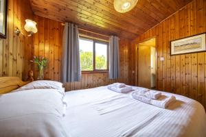 a bedroom with a large bed in a wooden room at L4 - Porthbeor in Truro
