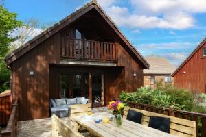 a house with a deck with a table and chairs at E40 - Kiberick in Truro