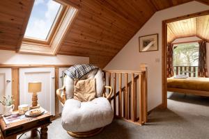 a living room with a chair and a staircase at E40 - Kiberick in Truro