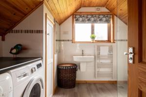 a laundry room with a washing machine and a sink at E40 - Kiberick in Truro