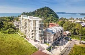 an aerial view of a white apartment building with the water at Breezy Condo in Aonang in Ao Nang Beach