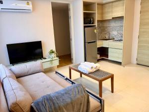 a living room with a couch and a table at Breezy Condo in Aonang in Ao Nang Beach +2 photos
