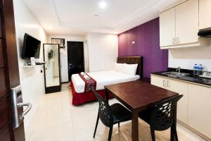 a small hotel room with a bed and a table at Obrero Suites Davao in Davao City