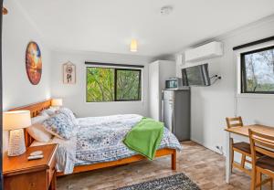 a bedroom with a bed and a desk at Country Nirvana in Pataua
