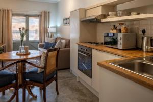 a kitchen with a table and a small kitchen with a couch at Eunoia Cottage in Paarl