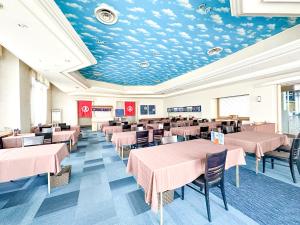 a dining room with pink tables and chairs at 汐の丸 in Imabari