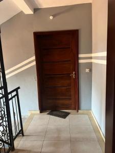 a wooden door in a room with a tile floor at HD Luxury Apparts in Yaoundé