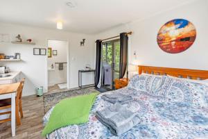 a bedroom with a bed and a desk and a sink at Country Nirvana in Pataua