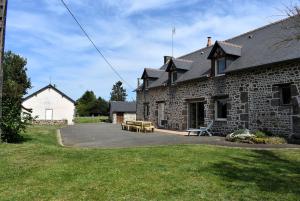 a brick building with a picnic table in front of it at Gîte La Mancellière - Maison familiale 12-15 pers, grand jardin, jeux & pétanque - Pleine nature in Cigné