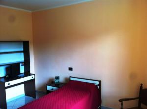 Roccaforte MondovìにあるResidenza Nonna Luciaのベッドルーム(赤いベッド1台、テレビ付)