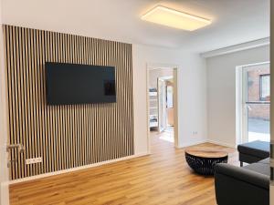 a living room with a flat screen tv on a wall at Apartment "Paris - Amsterdam" in Korschenbroich
