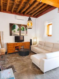 a living room with a couch and a tv at Can Pep Pardal in Sant Miquel de Balansat