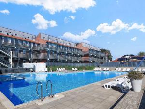 a large swimming pool in front of a building at 6 person holiday home on a holiday park in Faaborg in Faaborg