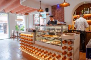 a man standing behind a counter in a bakery at Hotel Kailash Kutee in Kathmandu