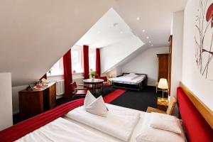 a bedroom with a large bed and a room with a bed at Design-Boutique Hotel Vosteen in Nuremberg