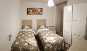 1 Schlafzimmer mit 2 Betten und einem Kühlschrank in der Unterkunft Sweet House in Sauze dʼOulx