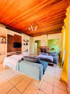 a large bedroom with two beds and a wooden ceiling at Clock Inn Self Catering Accommodation in Gaborone