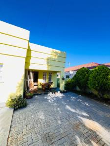 a house with a stone driveway in front of it at Clock Inn Self Catering Accommodation in Gaborone