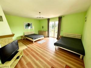 a room with two beds and a flat screen tv at Villa Henry in Grzybowo +27 photos