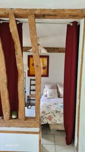 a bedroom with a bed with red curtains in it at Les Gites de la Renardière in Gueures