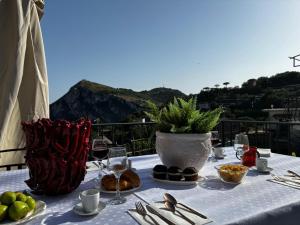 a table with a white vase and a table with food at Torre Saracena Massa Lubrense in Massa Lubrense