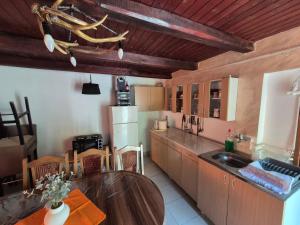 a kitchen with a wooden table and a wooden ceiling at Vikendica Bagremov hlad Apatin in Apatin
