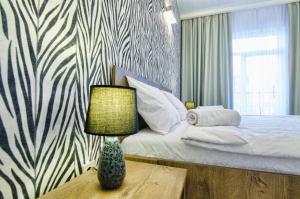 um quarto com uma cama e uma mesa com um candeeiro em Apartments Alfa Tsekhova 1 em Lviv