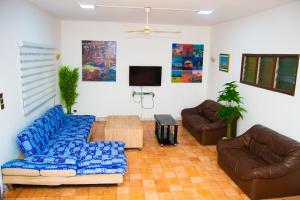 a living room with couches and a flat screen tv at Guesthouse Chez Marco in Cotonou